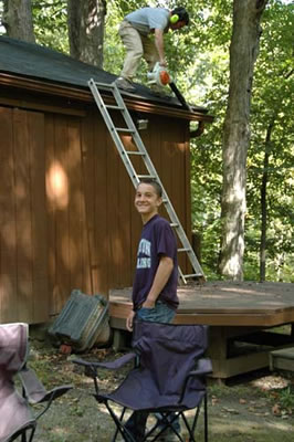 Jim clears the roof of branches with assist from Ross