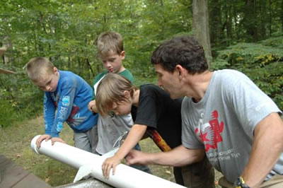 Boys helping Jim cut down a plastic pipe to make the Time Capsule
