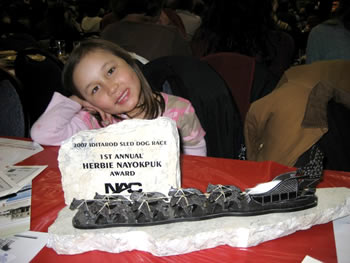 Tahayla Baker (John's daughter) with the award given Uncle Louis