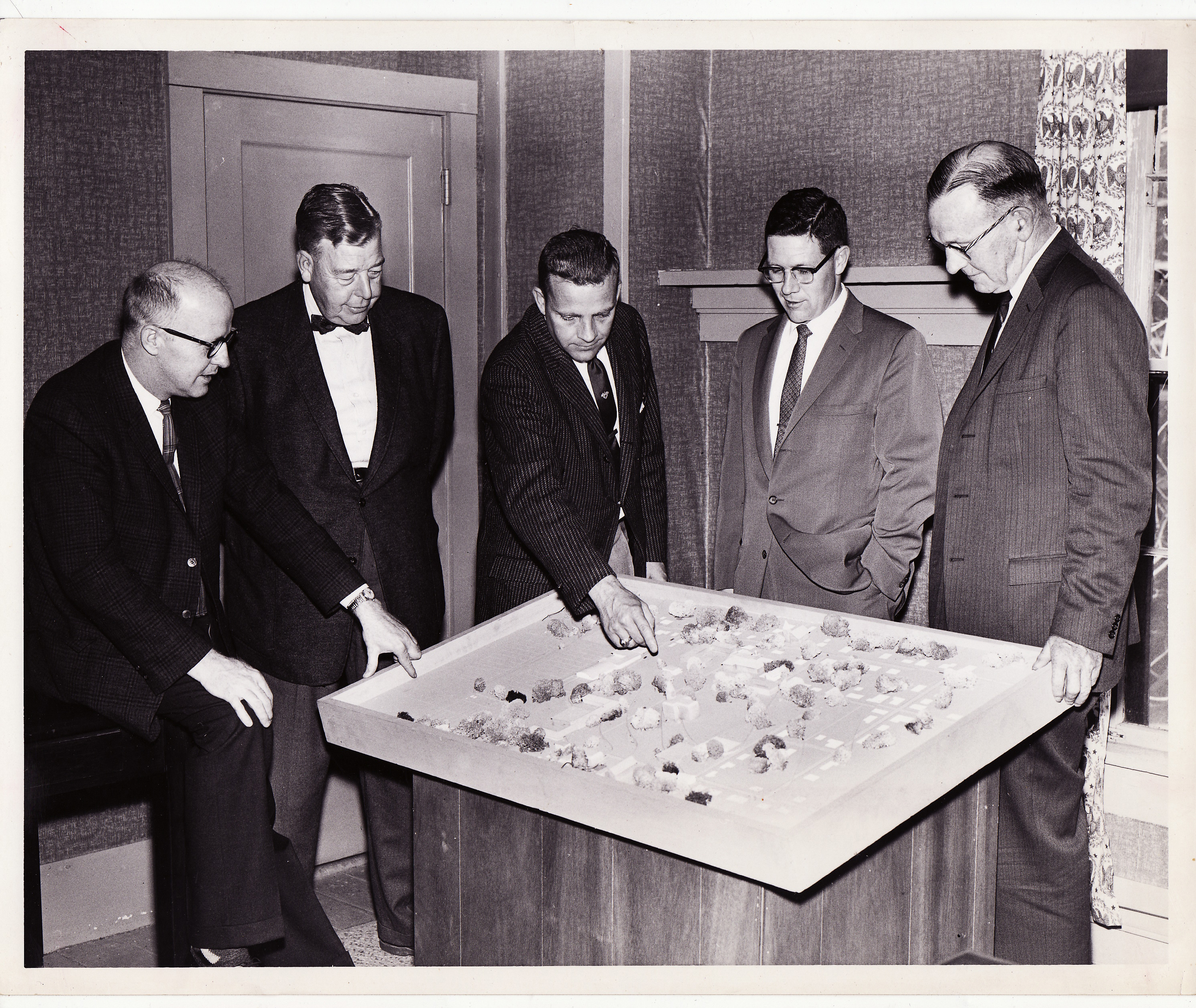 There isn't a no explaination on this photo but looks like Chuck is discussing a model of the campus. The date is May, 1960.