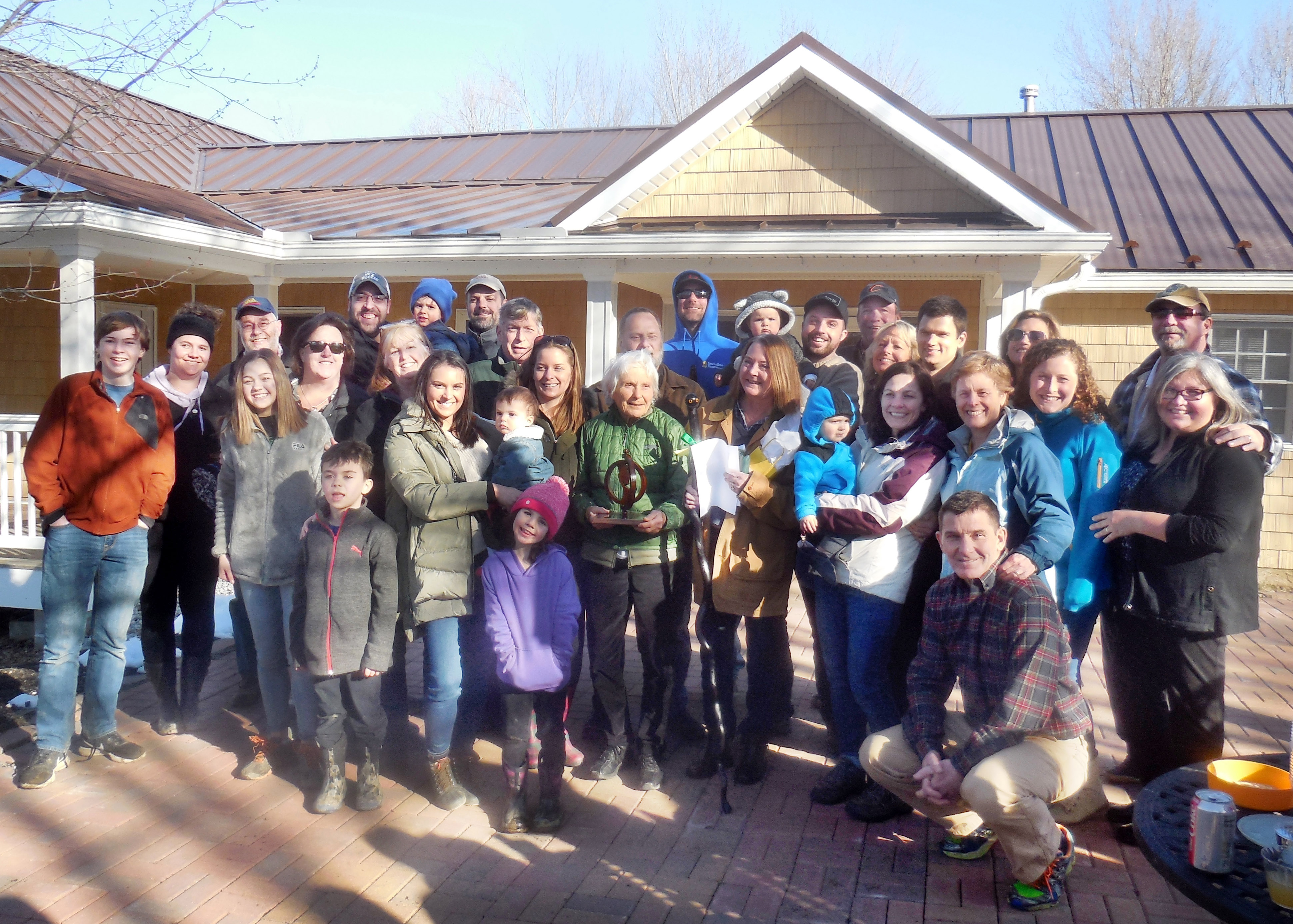 The Henry family surrounding Jeanne and her award
